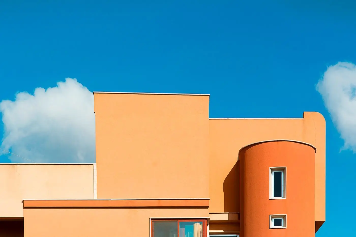Oranje gevel van een modern huis tegen een blauwe lucht